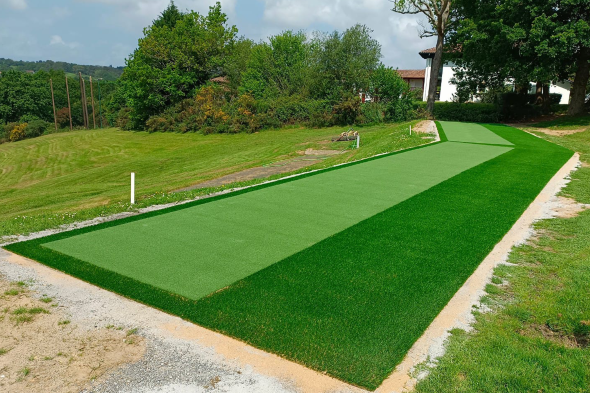 Austin Outdoor tee line consisting of one continuous green synthetic grass strip surrounded by trees